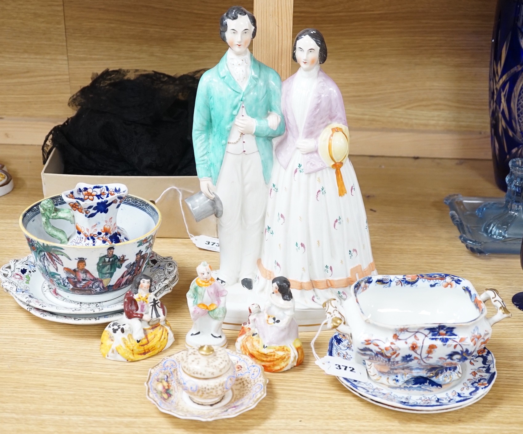 A pair of Staffordshire porcellaneous groups of children with a King Charles spaniel and a figure of Grimaldi the clown, c.1830-50 (3). Provenance - Dennis G. Rice collection. Together with other mixed ceramics